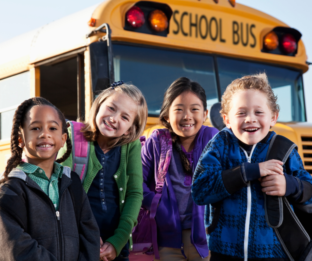 children in front of school bus.